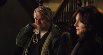 Movie still from “The Savages” (2007), directed by Tamara Jenkins – A man and a woman sitting next to each other on stairs; Medium shot, Over the shoulder angle