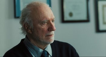 Movie still from “The Savages” (2007), directed by Tamara Jenkins – An older man wearing a suit and tie; Close Up shot, Over the shoulder angle