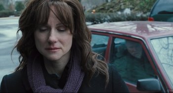 Movie still from “The Savages” (2007), directed by Tamara Jenkins – A person with her eyes closed near a car; Close Up shot, Over the shoulder angle