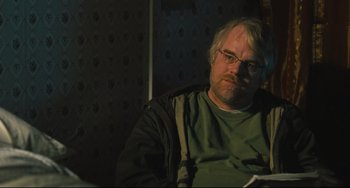Movie still from “The Savages” (2007), directed by Tamara Jenkins – A man sitting in front of a wall; Close Up shot, Over the shoulder angle