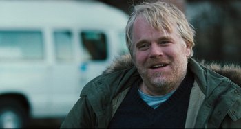Movie still from “The Savages” (2007), directed by Tamara Jenkins – A person with a beard smiling; Close Up shot, Over the shoulder angle