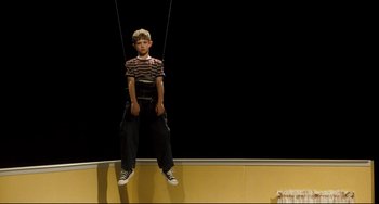 Movie still from “The Savages” (2007), directed by Tamara Jenkins – A young boy is suspended in the air by a rope; Wide shot, Low angle