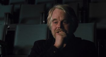 Movie still from “The Savages” (2007), directed by Tamara Jenkins – A person sitting down with his hand under his chin; Close Up shot, Over the shoulder angle