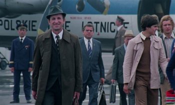 Movie still from “The Scar” (1976), directed by Krzysztof Kieslowski – A group of men in suits and hats walking down a street; Wide shot, Low angle