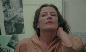 Movie still from “The Scar” (1976), directed by Krzysztof Kieslowski – A person with her hand on her head; Close Up shot, Low angle