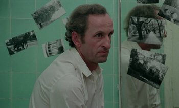 Movie still from “The Scar” (1976), directed by Krzysztof Kieslowski – A man in white shirt looking into a bathroom mirror; Medium shot, Over the shoulder angle