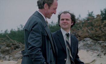 Movie still from “The Scar” (1976), directed by Krzysztof Kieslowski – A couple of men standing next to each other; Medium shot, Low angle