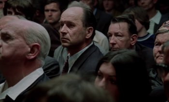 Movie still from “The Scar” (1976), directed by Krzysztof Kieslowski – A group of people sitting in a room; Medium shot, High angle