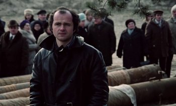 Movie still from “The Scar” (1976), directed by Krzysztof Kieslowski – A group of people standing in a field; Close Up shot, Low angle