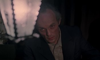 Movie still from “The Scar” (1976), directed by Krzysztof Kieslowski – A man in a suit looking at the camera; Close Up shot, Low angle