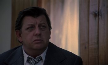 Movie still from “The Scar” (1976), directed by Krzysztof Kieslowski – A person wearing a suit and tie; Close Up shot, Low angle