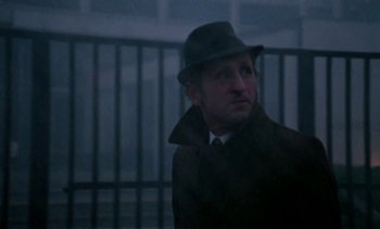 Movie still from “The Scar” (1976), directed by Krzysztof Kieslowski – A man wearing a hat and a coat; Close Up shot, Low angle