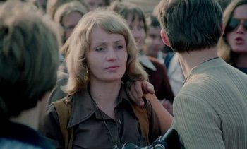 Movie still from “The Scar” (1976), directed by Krzysztof Kieslowski – A woman is looking at a man in a crowd of people; Close Up shot, Over the shoulder angle