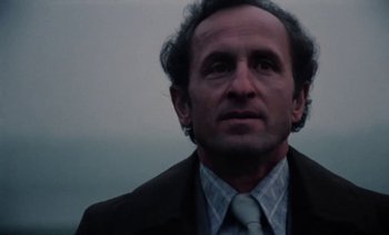 Movie still from “The Scar” (1976), directed by Krzysztof Kieslowski – A person wearing a suit and tie; Close Up shot, Low angle