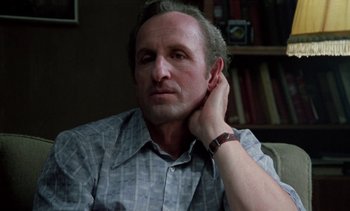 Movie still from “The Scar” (1976), directed by Krzysztof Kieslowski – A person with his hand near his ear; Close Up shot, Low angle