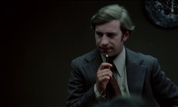 Movie still from “The Scar” (1976), directed by Krzysztof Kieslowski – A man wearing a suit and tie holding a tie; Close Up shot, Low angle