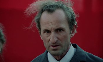 Movie still from “The Scar” (1976), directed by Krzysztof Kieslowski – A person wearing a suit and tie; Close Up shot, Low angle