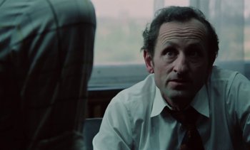 Movie still from “The Scar” (1976), directed by Krzysztof Kieslowski – A man wearing a white dress shirt and a red neck tie; Close Up shot, Low angle