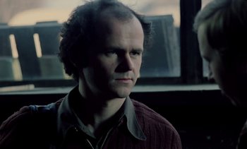 Movie still from “The Scar” (1976), directed by Krzysztof Kieslowski – A person wearing a jacket; Close Up shot, Low angle