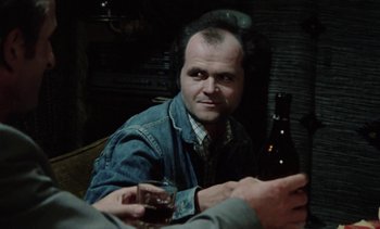 Movie still from “The Scar” (1976), directed by Krzysztof Kieslowski – A man sitting at a table with a glass of wine; Close Up shot, Over the shoulder angle