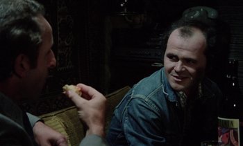 Movie still from “The Scar” (1976), directed by Krzysztof Kieslowski – Two men are sitting and eating a sandwich; Close Up shot, Over the shoulder angle