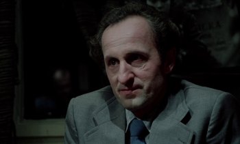 Movie still from “The Scar” (1976), directed by Krzysztof Kieslowski – A person wearing a suit and tie; Close Up shot, Low angle