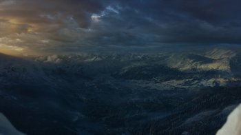 Movie still from “Game of Thrones” (2011), created by D.B. Weiss – A view of a mountain range from a helicopter; Extreme Wide shot, High angle