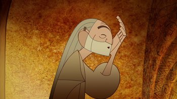 Movie still from “The Secret of Kells” (2009), directed by Nora Twomey – An old man with long hair and a white beard is holding his hand up to his face; Close Up shot, Over the shoulder angle
