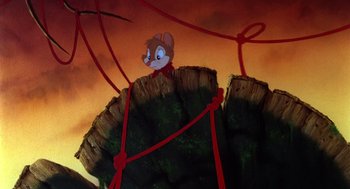 Movie still from “The Secret of NIMH” (1982), directed by Don Bluth – A mouse sitting on top of a tree stump; Wide shot, Low angle