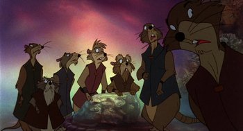 Movie still from “The Secret of NIMH” (1982), directed by Don Bluth – A group of people standing next to each other in front of a mountain; Medium shot, Low angle