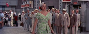 Movie still from “The Seven Year Itch” (1955), directed by Billy Wilder – A woman in a green and white dress walking down a street; Medium shot, Low angle