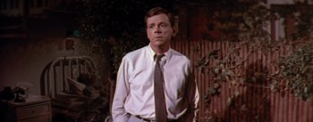 Movie still from “The Seven Year Itch” (1955), directed by Billy Wilder – A man wearing a white shirt and a brown tie; Close Up shot, Over the shoulder angle