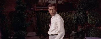 Movie still from “The Seven Year Itch” (1955), directed by Billy Wilder – A man in a white dress shirt and a tie; Medium shot, Over the shoulder angle