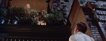 Movie still from “The Seven Year Itch” (1955), directed by Billy Wilder – A building with a lot of plants on the top of the building; Medium shot, Low angle