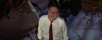 Movie still from “The Seven Year Itch” (1955), directed by Billy Wilder – A man wearing a white dress shirt and a red tie; Close Up shot, Overhead angle