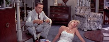 Movie still from “The Seven Year Itch” (1955), directed by Billy Wilder – A man and a woman sitting on the floor; Medium shot, High angle