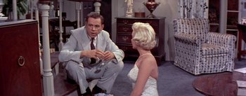 Movie still from “The Seven Year Itch” (1955), directed by Billy Wilder – A man and a woman sitting on the floor; Medium shot, Over the shoulder angle