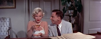 Movie still from “The Seven Year Itch” (1955), directed by Billy Wilder – A man and a woman sitting at a table with a glass of wine; Medium shot, Over the shoulder angle