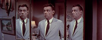 Movie still from “The Seven Year Itch” (1955), directed by Billy Wilder – An older man wearing a suit and tie in front of a mirror; Close Up shot, Low angle