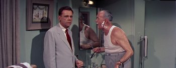 Movie still from “The Seven Year Itch” (1955), directed by Billy Wilder – Two men in a bathroom one of them is brushing his teeth; Medium shot, Over the shoulder angle