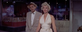 Movie still from “The Seven Year Itch” (1955), directed by Billy Wilder – A man and a woman standing next to each other; Medium shot, Low angle