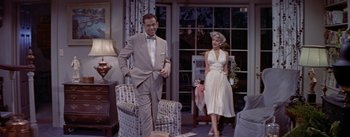 Movie still from “The Seven Year Itch” (1955), directed by Billy Wilder – A man and a woman standing in a living room; Medium shot, Low angle