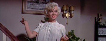 Movie still from “The Seven Year Itch” (1955), directed by Billy Wilder – A woman in a white dress is holding a toothbrush; Medium shot, Low angle