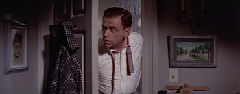 Movie still from “The Seven Year Itch” (1955), directed by Billy Wilder – A man in a white dress shirt and tie looking at the camera; Medium shot, Over the shoulder angle