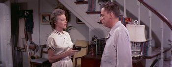 Movie still from “The Seven Year Itch” (1955), directed by Billy Wilder – An older woman holding a gun talking to an older man; Medium shot, Low angle