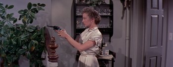 Movie still from “The Seven Year Itch” (1955), directed by Billy Wilder – A woman in a white dress is holding a remote control; Medium shot, Low angle