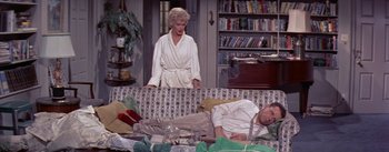 Movie still from “The Seven Year Itch” (1955), directed by Billy Wilder – A man and a woman are sitting on a couch; Medium shot, High angle