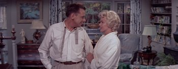 Movie still from “The Seven Year Itch” (1955), directed by Billy Wilder – An older man and a younger woman standing next to each other in front of a window; Medium shot, Low angle