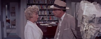 Movie still from “The Seven Year Itch” (1955), directed by Billy Wilder – A man and a woman talking in a library; Medium shot, Over the shoulder angle