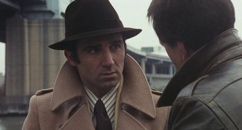 Movie still from “The Seven-Ups” (1973), directed by Philip D'Antoni – A person wearing a hat and a coat; Close Up shot, Over the shoulder angle